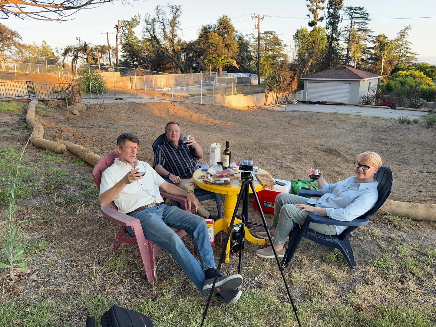 John Rabe, Christopher Still, and Amanda McIntosh in front of their property in Altadena. Rebuilding is going a little slower than they hoped.